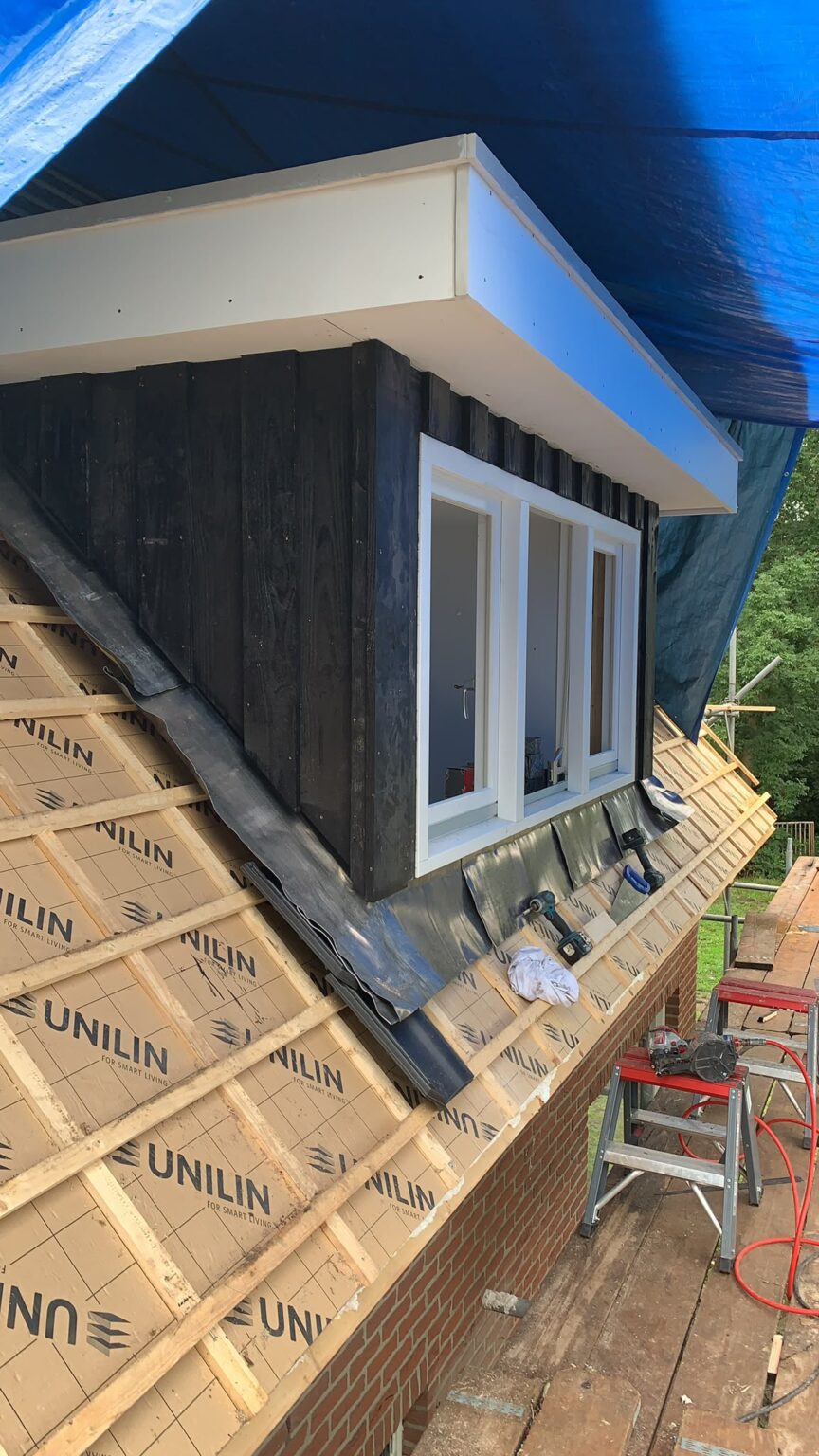 Nieuwe dakkapel met zwarte houten zijkanten op een geïsoleerd dak