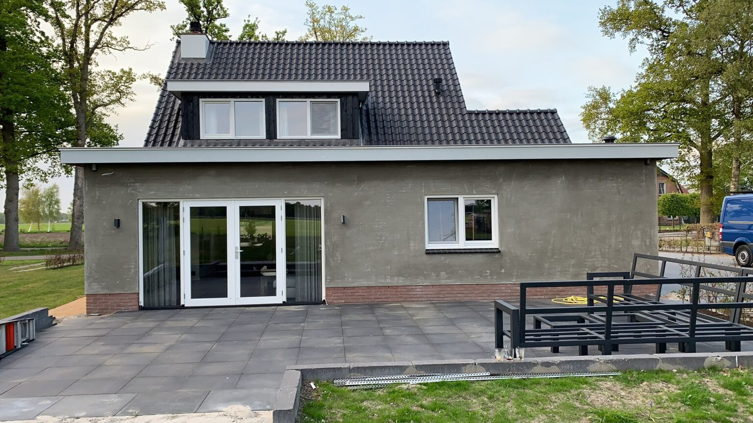 Achterkant met de aanbouw in de grijze onderlaag en het nieuwe terras