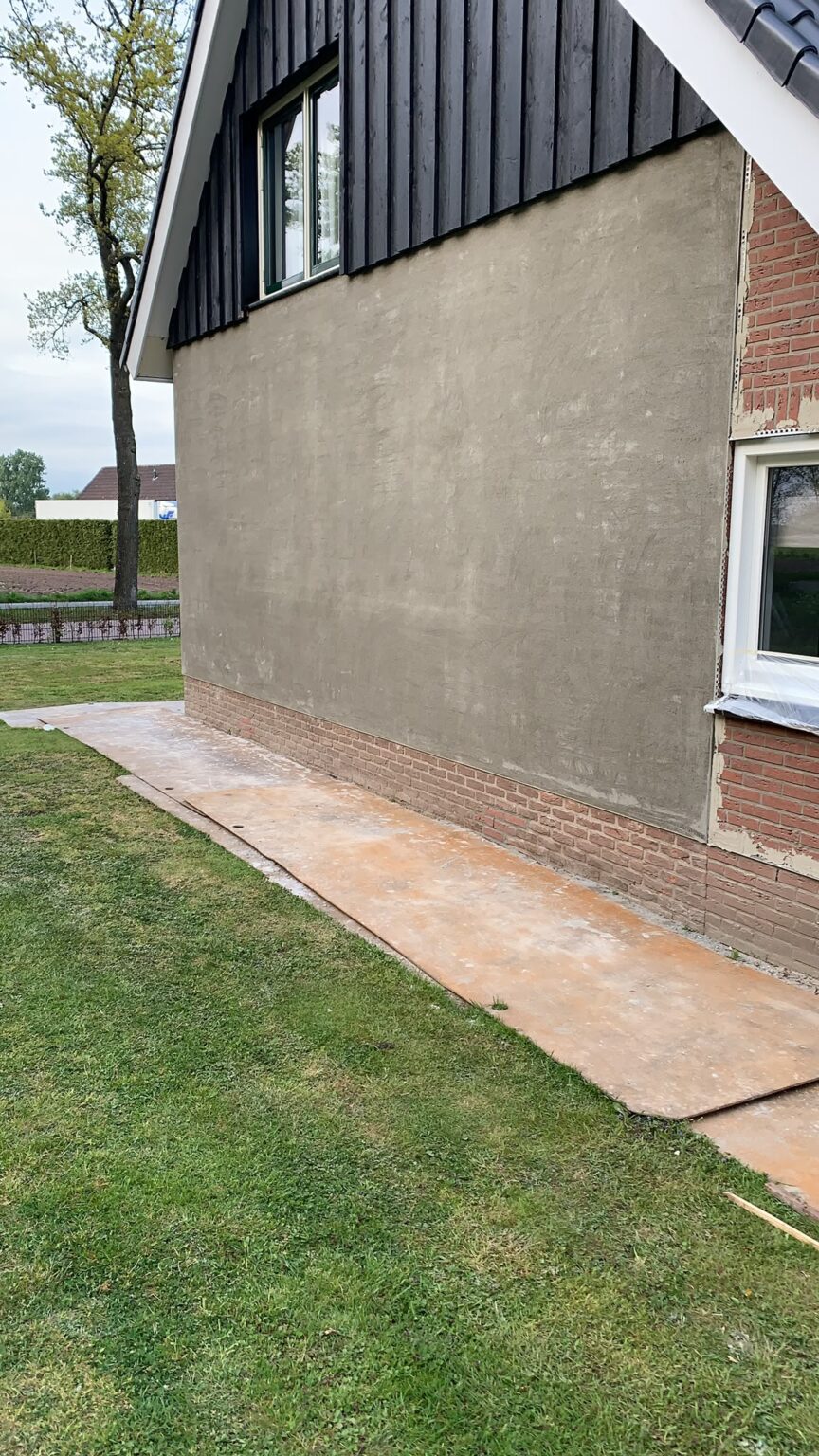 Zijgevel met grijze onderlaag en een topgevel in zwart hout