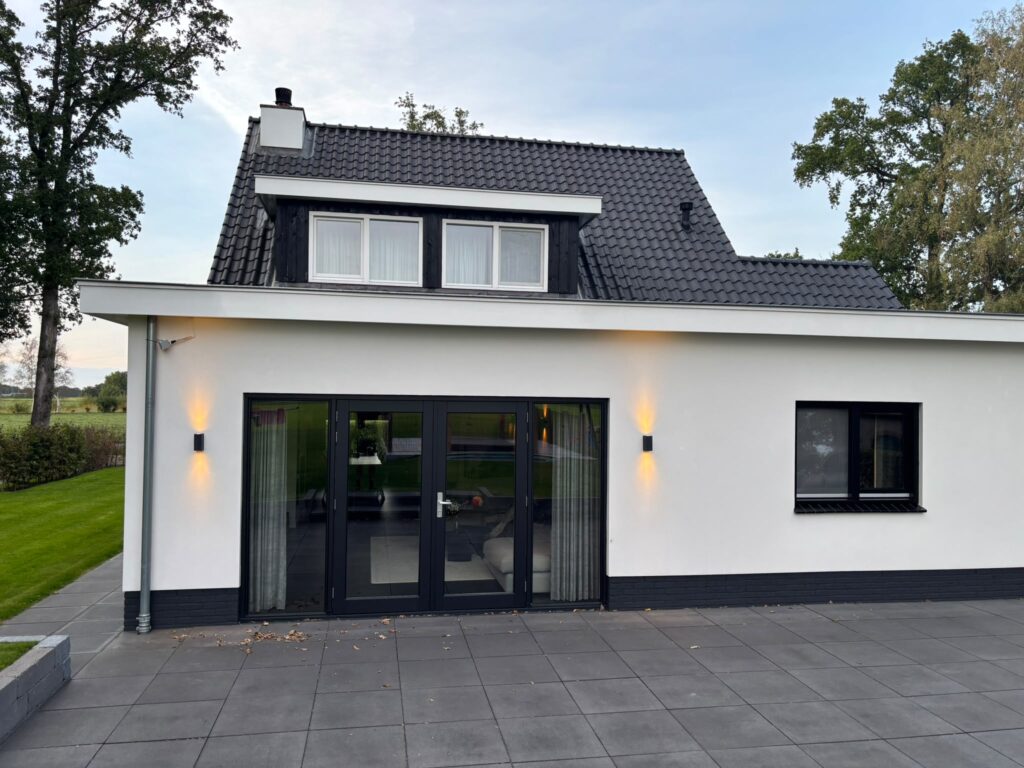 Achterkant van een verbouwde woning in De Glind met openslaande tuindeuren en dakkapel