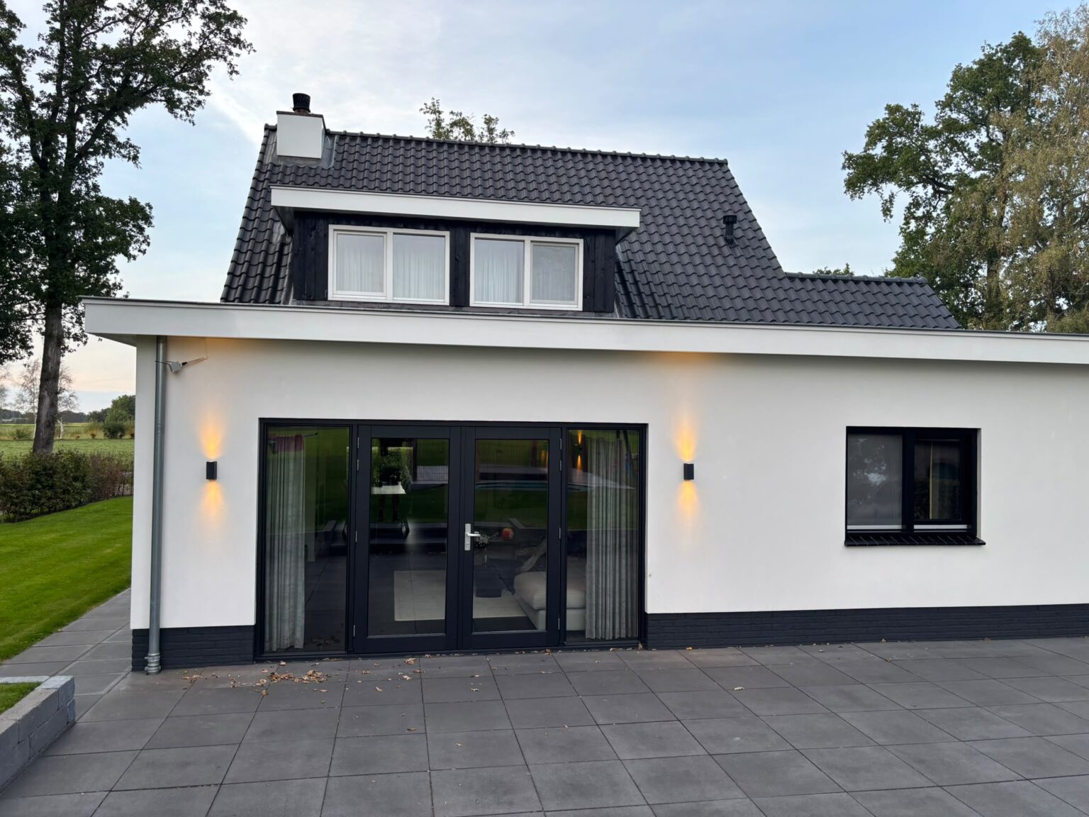 Achterkant van een verbouwde woning in De Glind met openslaande tuindeuren en dakkapel