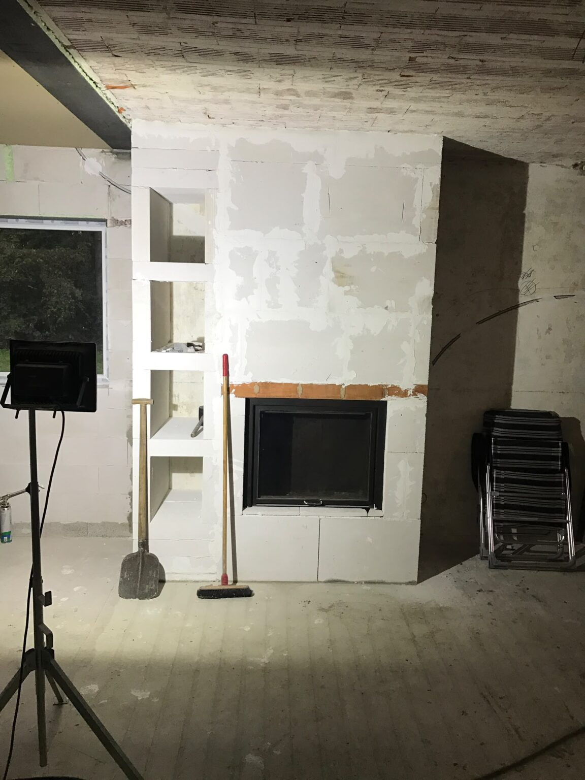 Ombouw van de inbouwhaard in aanbouw met nissen voor haardhout
