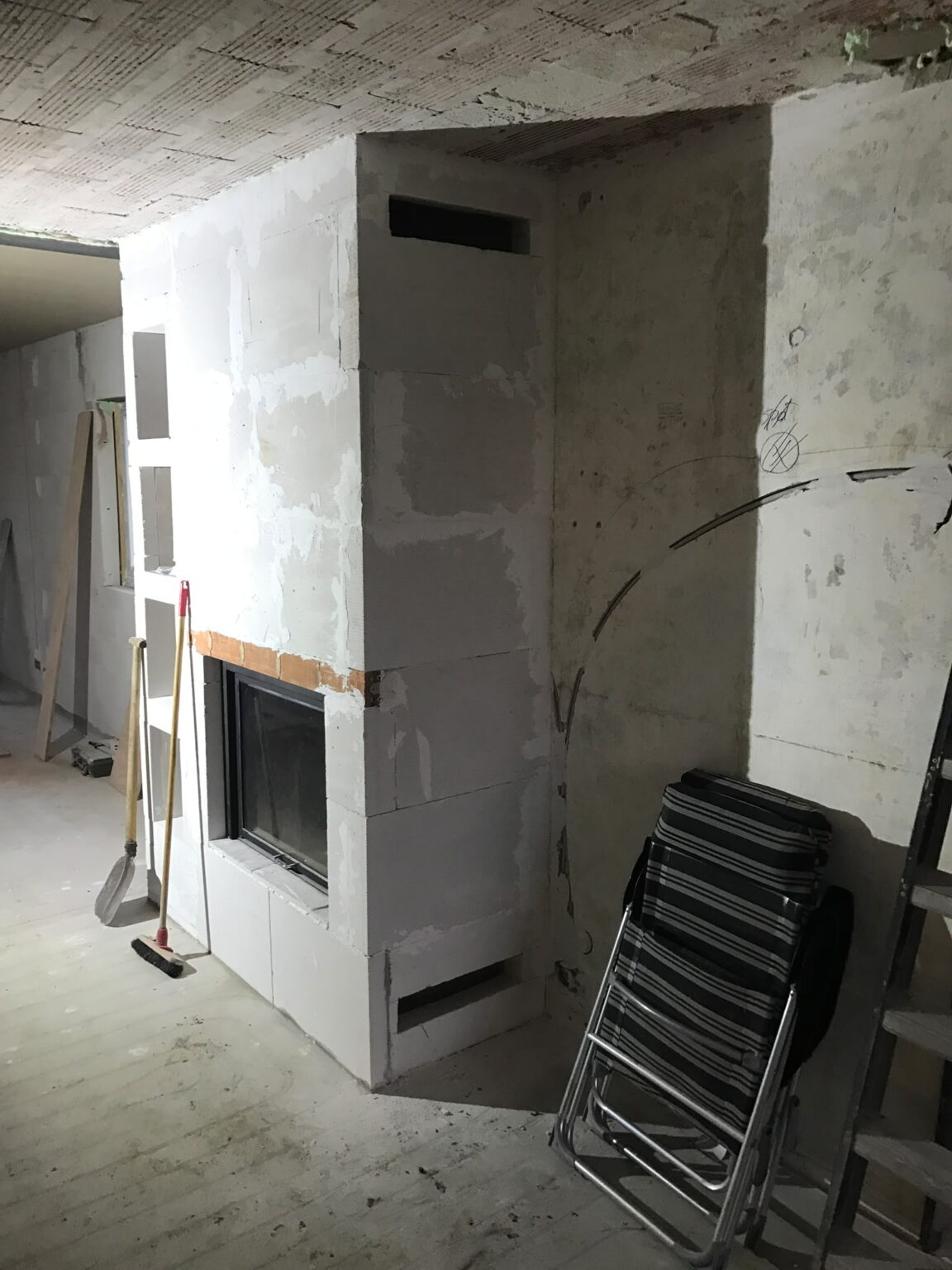 Zijkant van de haardombouw met openingen voor de ventilatieroosters