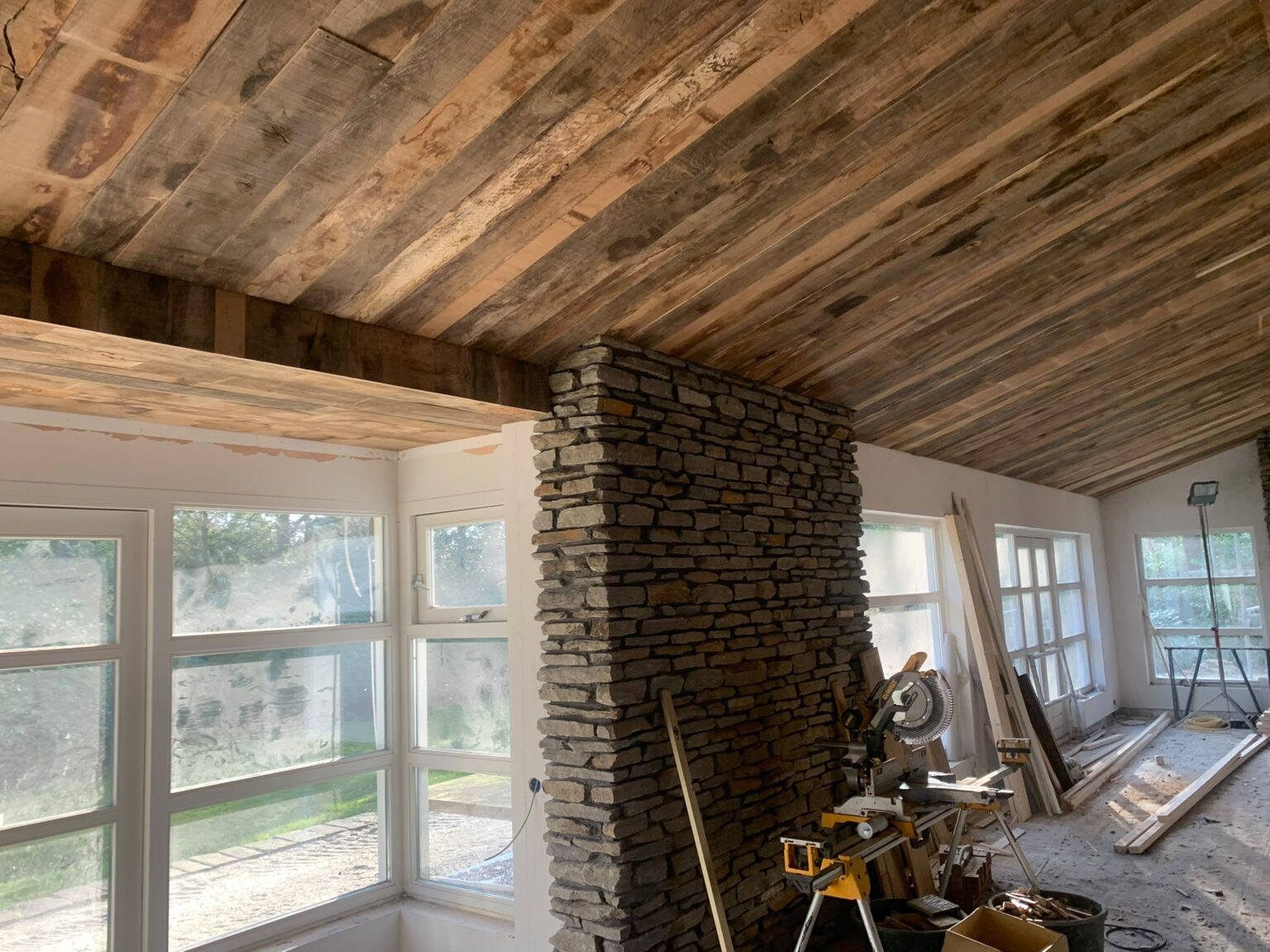 Houten plafond en natuurstenen kolom tijdens de verbouwing