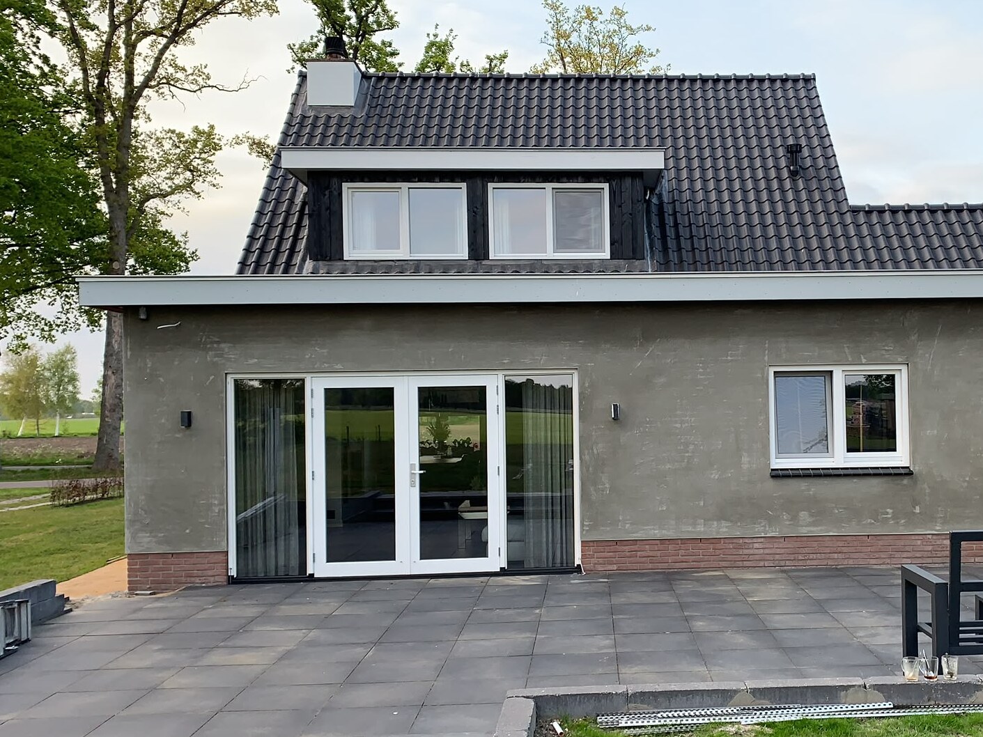 Achterkant van de woning in De Glind tijdens het stucwerk, met de grijze onderlaag