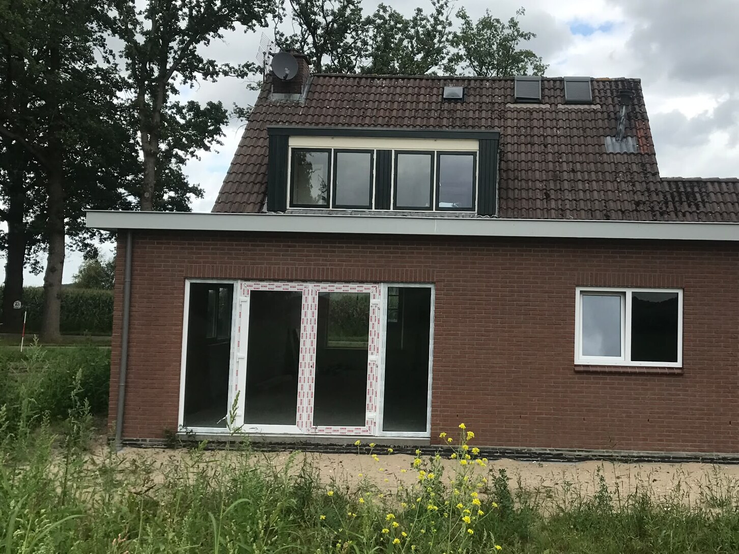 Achterkant van de woning in De Glind voor de verbouwing, met de aanbouw nog in metselwerk